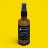 De-Loo-Loo organic bathroom spray — amber glass bottle with lemongrass, orange, and eucalyptus essential oils